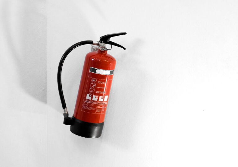 red fire extinguisher white wall